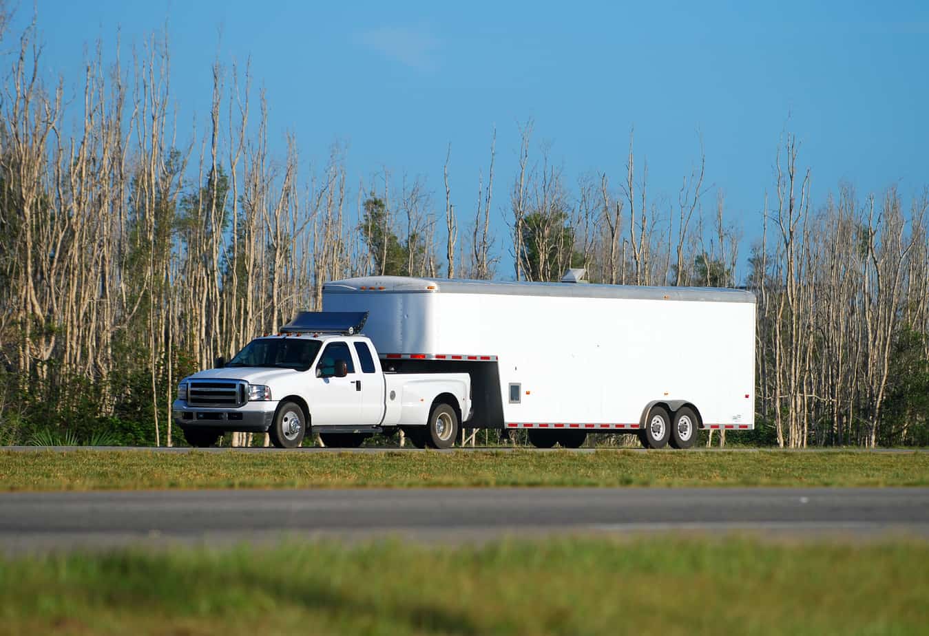 Dually pickup truck hitched to a large enclosed gooseneck trailer
