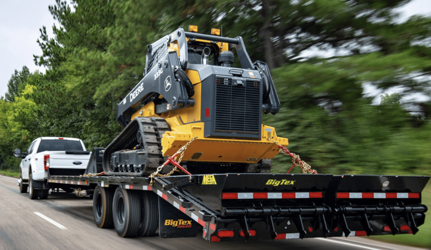 dually pickup towing a Big Tex equipment trailer loaded with a skid steer